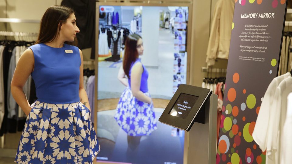 Image shows a girl standing in front of an interactive digital screen mirror