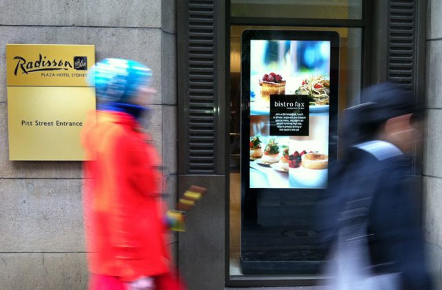 Image shows a digital screen outside a hotel and restaurant
