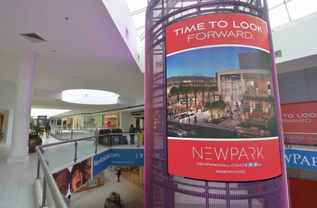 Image shows a large wrap-around digital screen in a shopping centre