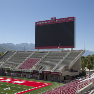 image shows a large scoreboard screen above American Football stadium stands