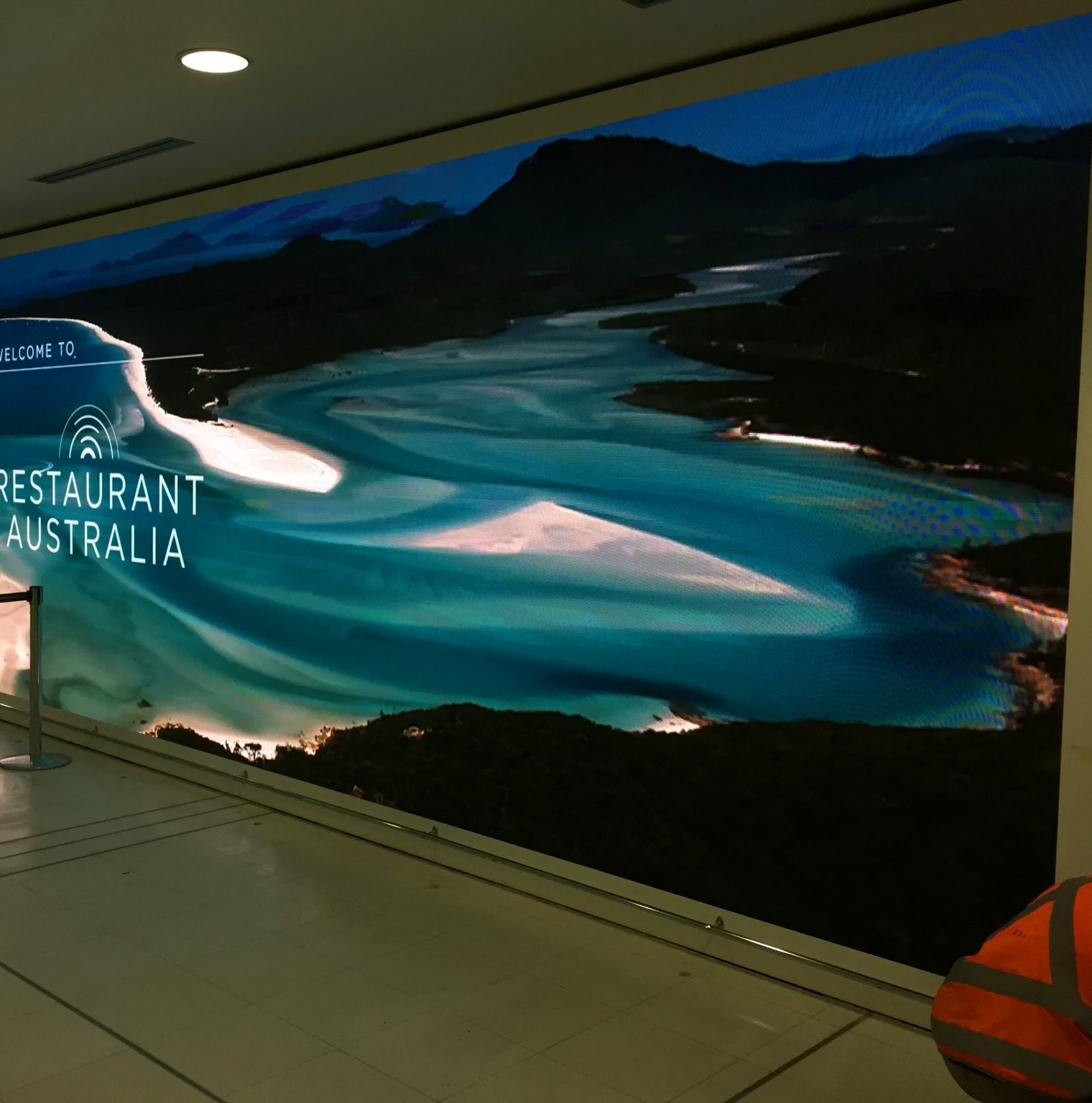 Image shows a large digital wall screen inside an airport