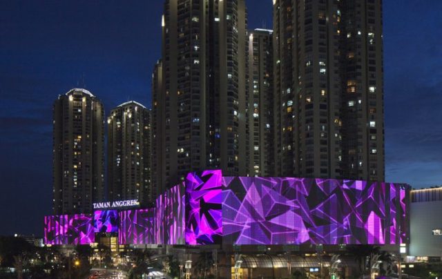 Image shows large digital screen display wrapping around a large hotel complex