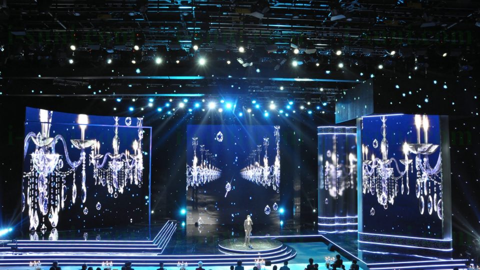Image shows Large screens displaying chandeliers as a backdrop for a stage production