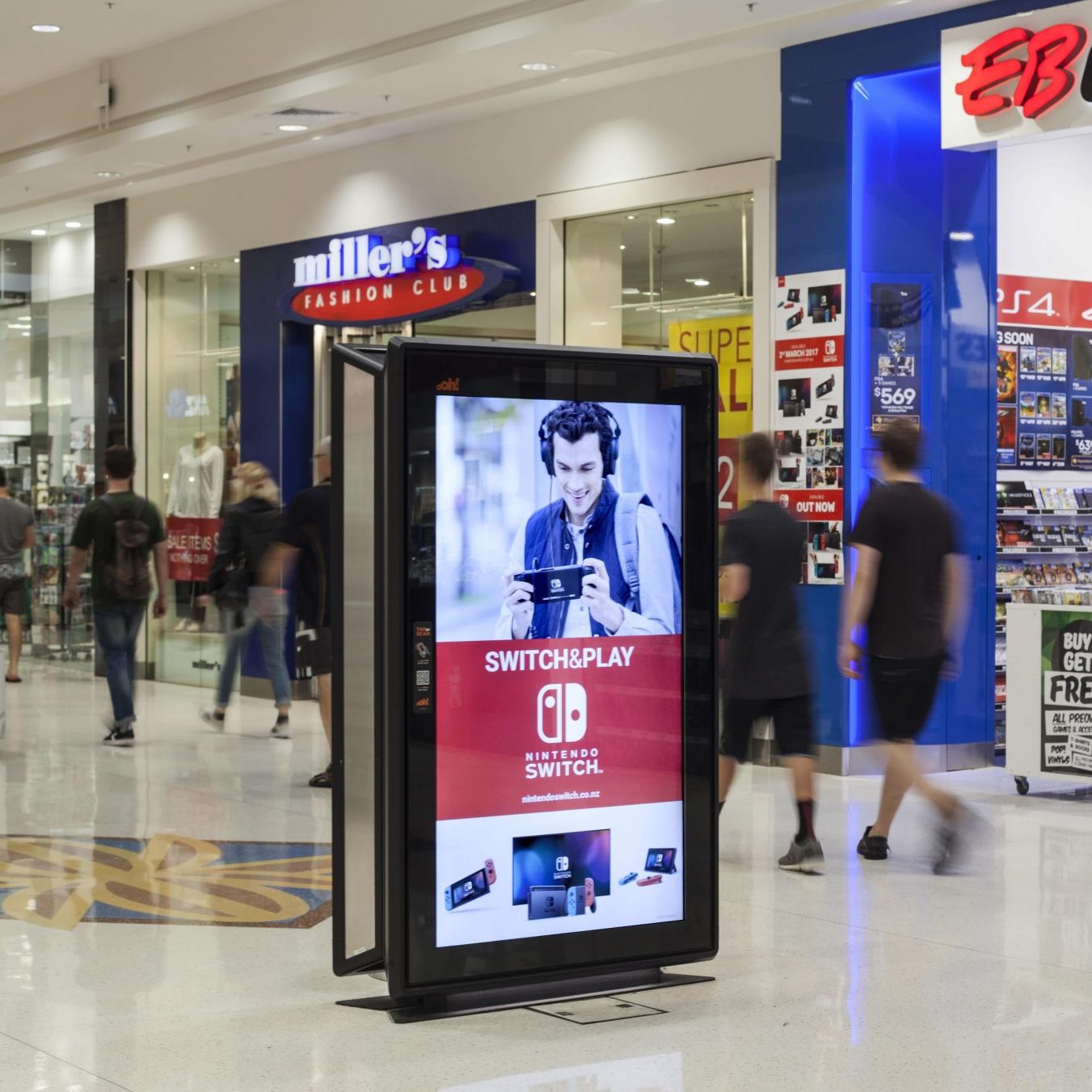 Image shows a free standing digital screen outside a shop