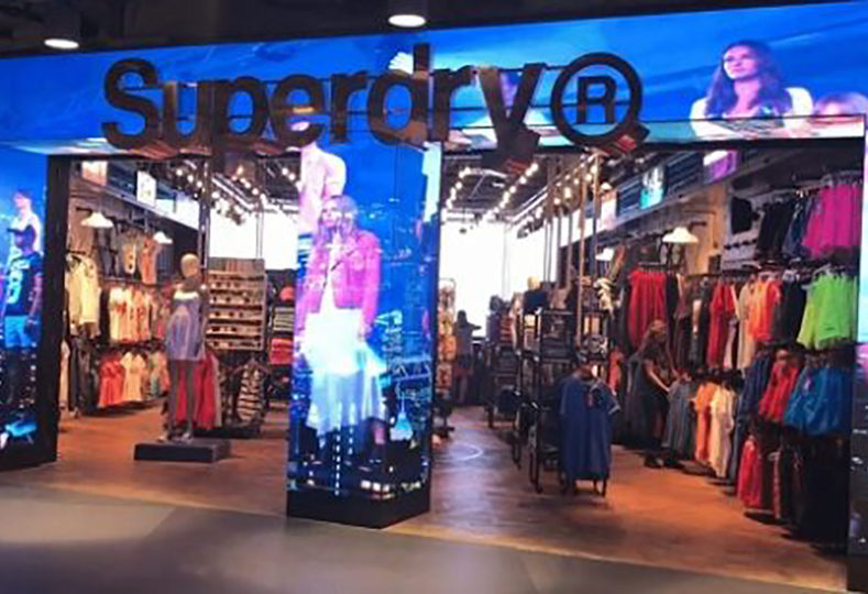 Image shows a digital screen around the outside of a clothing store front window and doors.